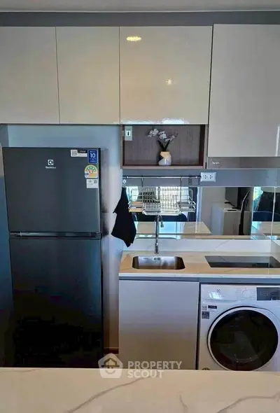 Modern kitchen with sleek appliances and stylish cabinetry in a contemporary apartment.
