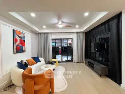 Modern living room with stylish decor, large TV, and cozy seating area, perfect for relaxation and entertainment.