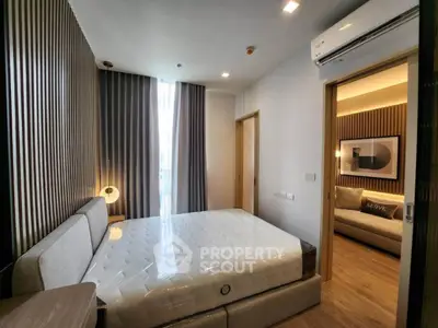 Modern bedroom with stylish decor and natural light, featuring a comfortable bed and sleek air conditioning unit.