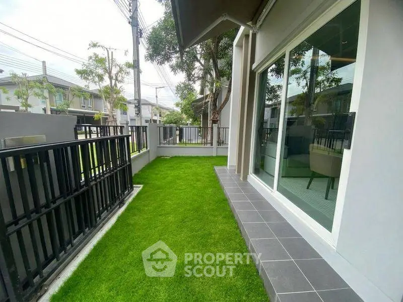 Charming townhouse with lush green garden and modern exterior design.