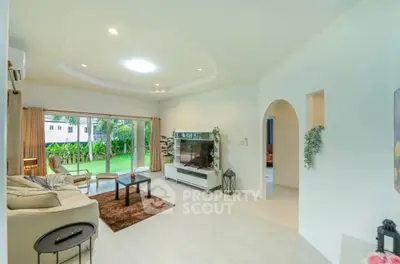Spacious living room with modern decor and garden view, perfect for relaxation and entertainment.