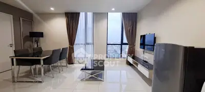 Modern living room with dining area and city view, featuring sleek furniture and large windows.