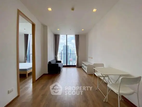 Modern apartment with wooden flooring and city view, featuring a cozy living area and dining space.