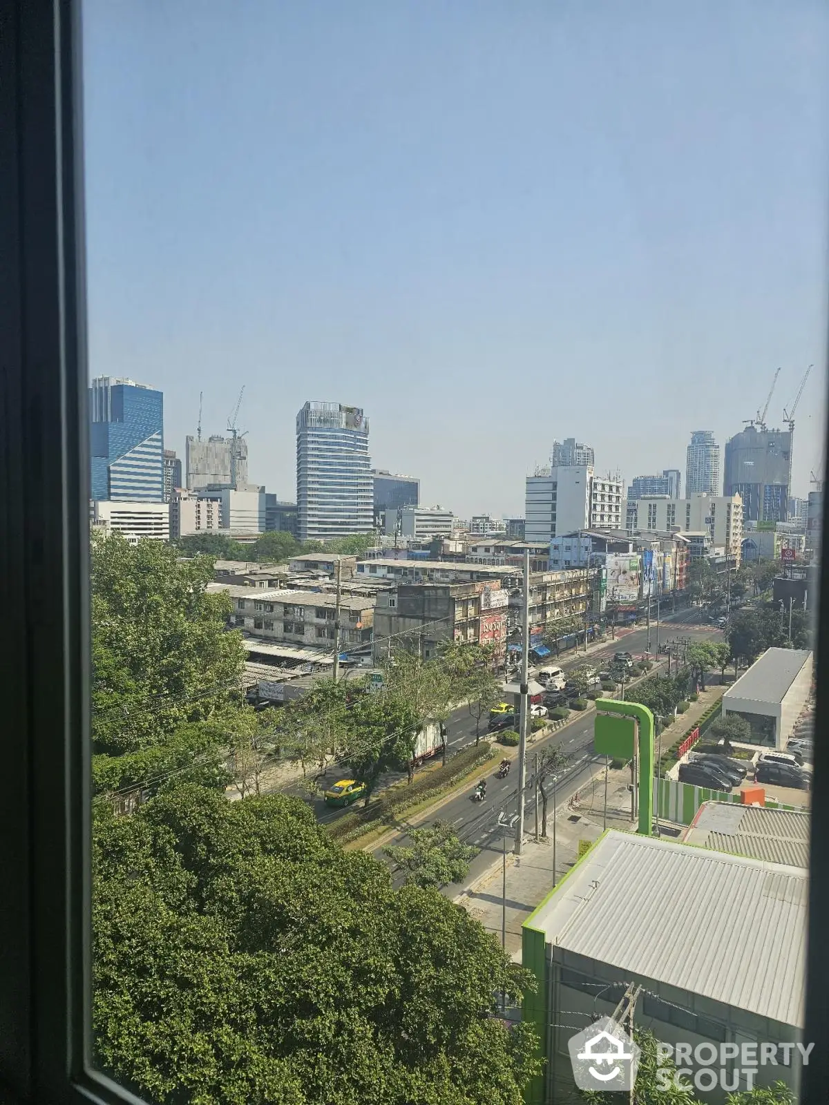 Stunning cityscape view from high-rise window showcasing urban skyline and vibrant street life.