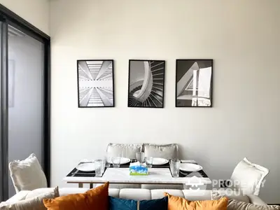 Chic modern living room with stylish sofa adorned with colorful cushions, complemented by a sleek coffee table and elegant wall art.