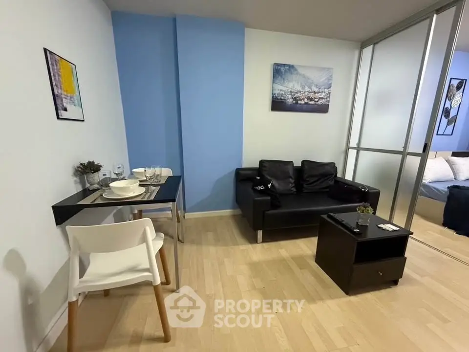 Modern living room with sleek black sofa and dining area in stylish apartment