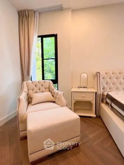 Elegant bedroom corner with plush armchair and natural light