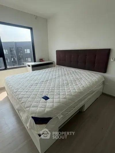 Spacious bedroom with large window and modern bed in a bright apartment