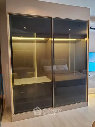 Modern bedroom with sleek glass wardrobe and ambient lighting