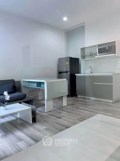 Modern open-layout kitchen with sleek appliances and cozy living area, perfect for contemporary living.