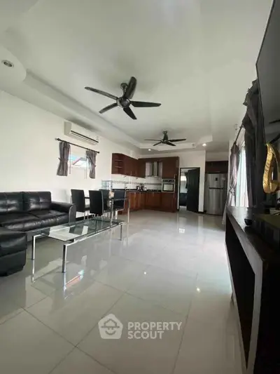 Spacious modern living room with open kitchen and sleek furnishings.