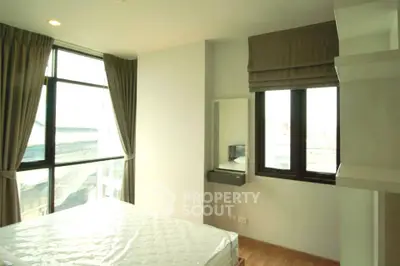 Bright bedroom with large windows and modern decor in a stylish apartment.