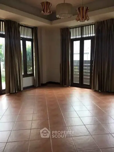 Spacious empty living room with large windows and elegant curtains