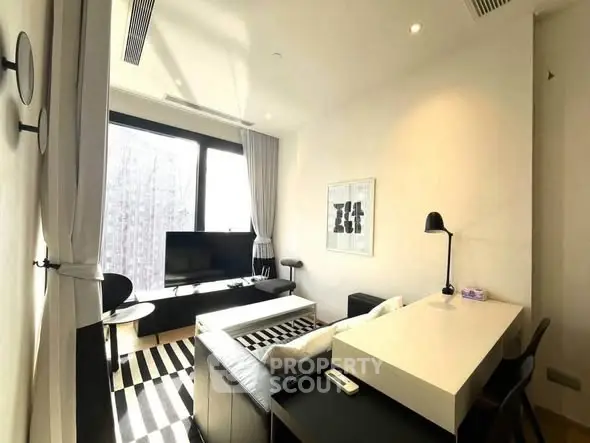Modern living room with sleek furniture and large window offering natural light.