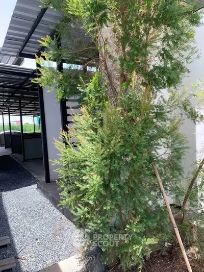 Modern building exterior with lush greenery and sleek design elements.