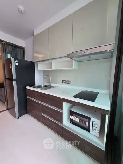 Modern kitchen with sleek cabinetry, built-in appliances, and minimalist design in a contemporary apartment.