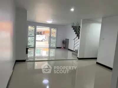Spacious modern living room with glossy floors and large windows in a contemporary home.