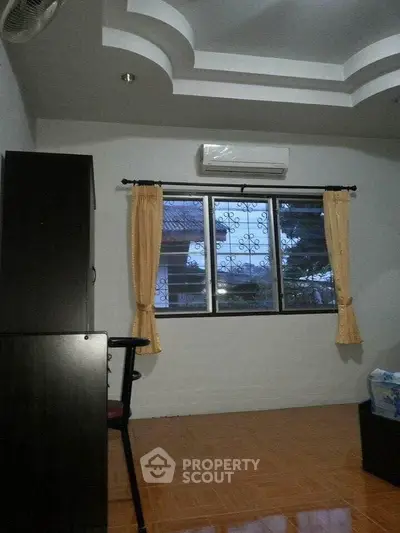 Cozy bedroom with air conditioning and window view, ideal for comfortable living.