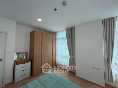Modern bedroom with large windows and wooden wardrobe in a stylish apartment.