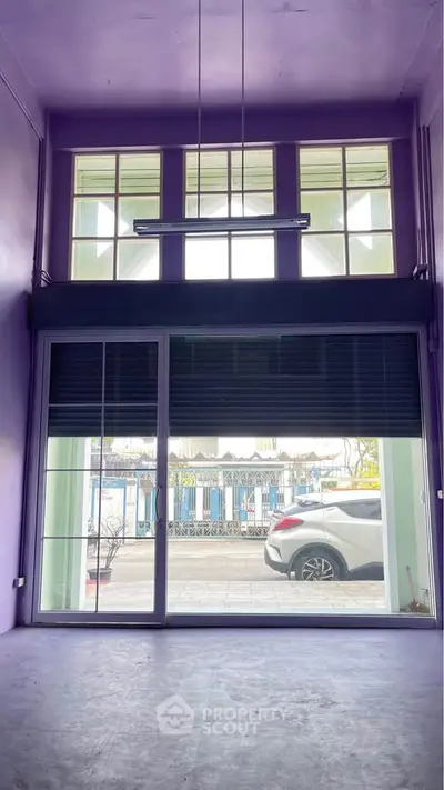 Spacious room with large windows and street view, ideal for commercial use or creative studio.