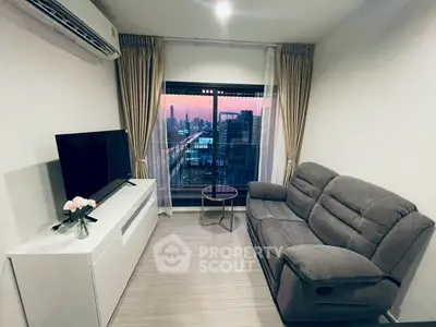 Modern living room with city view, featuring cozy sofa and large TV, perfect for relaxation.