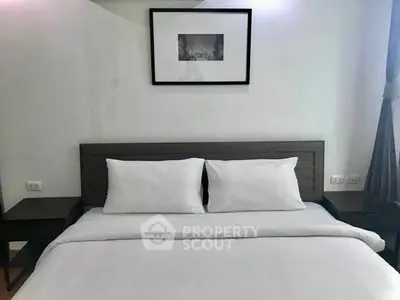Cozy bedroom with modern decor and framed artwork above the bed, perfect for relaxation.