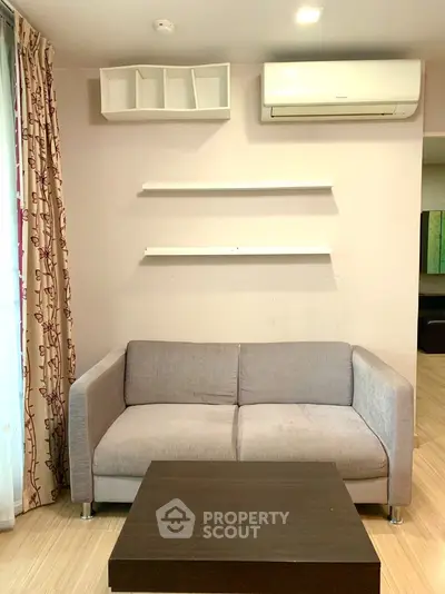 Cozy living room with modern sofa and air conditioning unit, perfect for relaxation.
