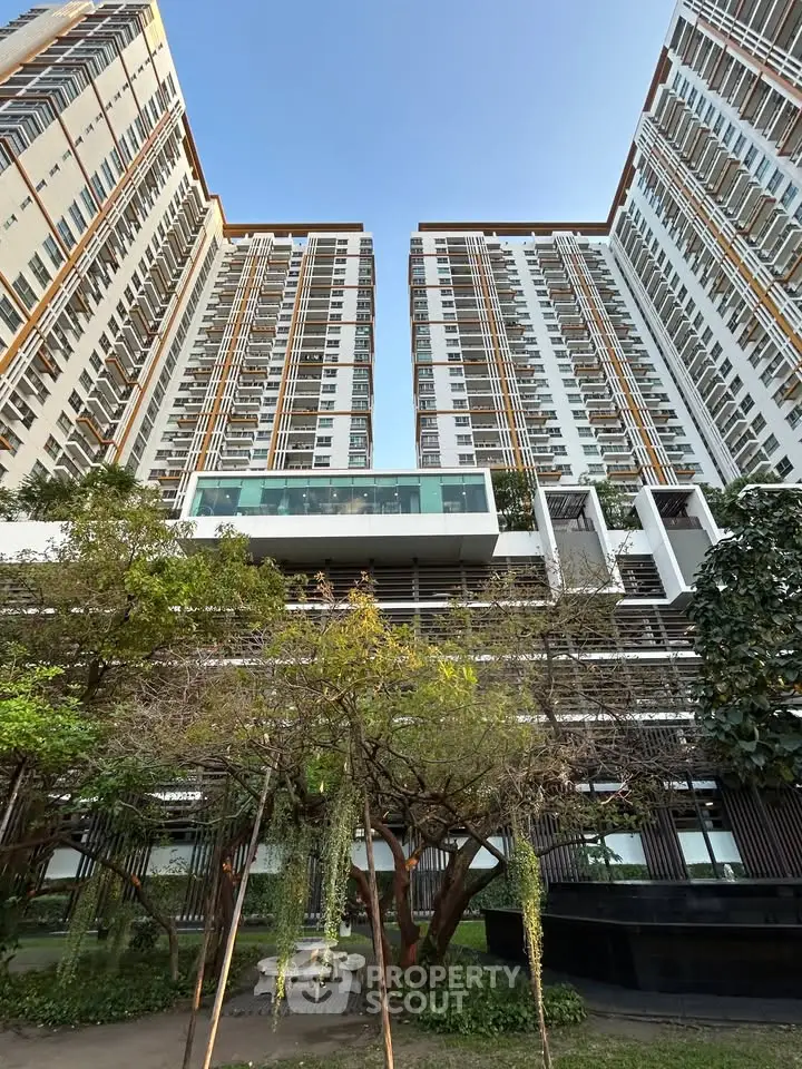 Stunning high-rise residential building with lush greenery and modern architecture.