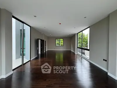 Spacious modern living room with large windows and hardwood floors