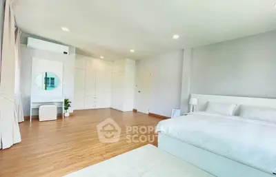 Spacious modern bedroom with elegant white decor and ample natural light