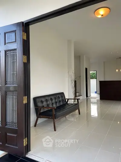 Spacious modern living area with sleek black sofa and elegant lighting