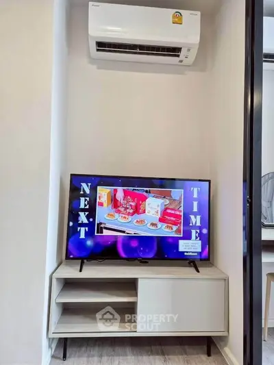 Modern living room with air conditioner and TV on stylish wooden stand.