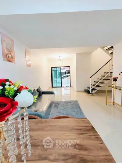Spacious modern living room with elegant decor and staircase, perfect for family gatherings.