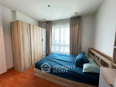 Modern bedroom with wooden flooring and stylish furniture in a cozy apartment.