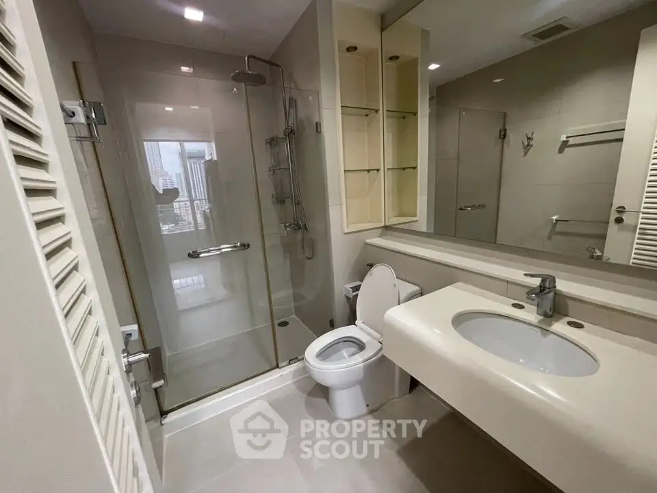 Modern bathroom with glass shower and sleek fixtures in urban apartment