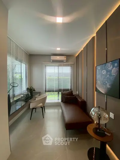 Modern living room with sleek furniture and large window offering natural light.