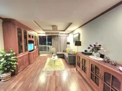 Spacious living room with elegant wooden furniture and balcony access