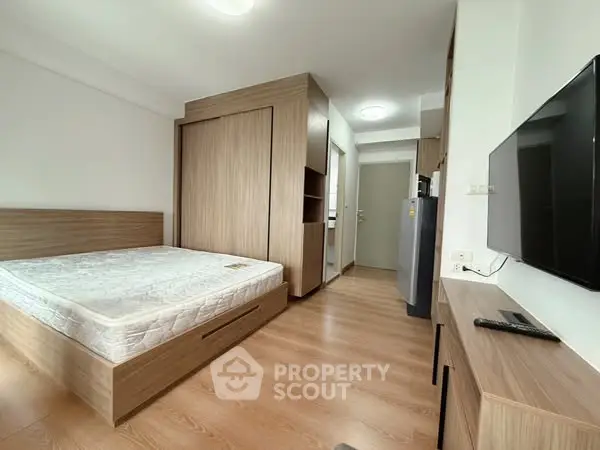Modern bedroom with wooden flooring and built-in wardrobe in a cozy apartment.