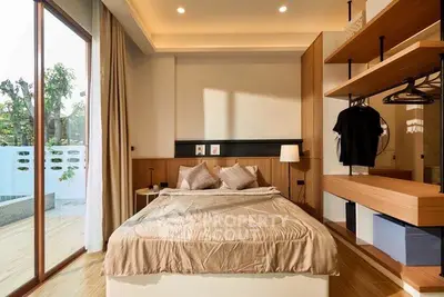 Modern bedroom with stylish decor and large window overlooking garden