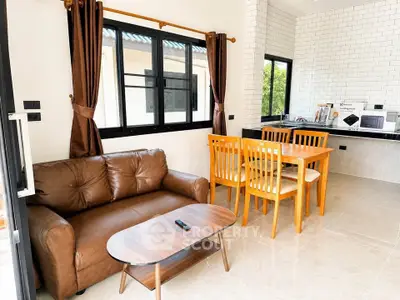 Modern living room with brown leather sofa and dining area in open layout