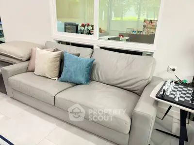 Modern living room with stylish sofa and chess set, perfect for relaxation and entertainment.