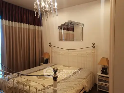 Elegant bedroom with vintage metal bed frame and chandelier lighting