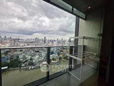 Stunning cityscape view from a high-rise balcony overlooking a river, perfect for urban living.