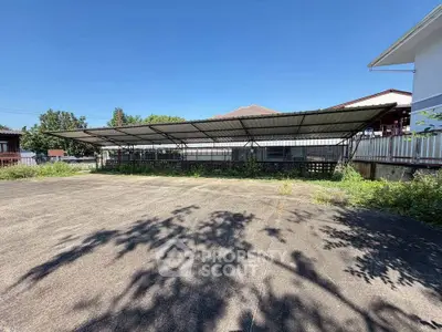 Spacious outdoor parking area with covered carport in a residential setting, ideal for multiple vehicles.