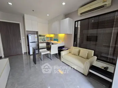 Modern open-layout living room with sleek kitchen and cozy seating area.
