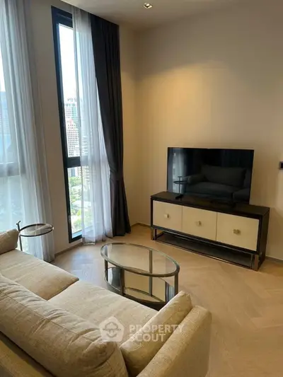 Modern living room with city view, elegant sofa, and sleek TV setup.