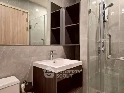Modern bathroom with sleek design, featuring a glass shower and stylish vanity in a contemporary apartment.