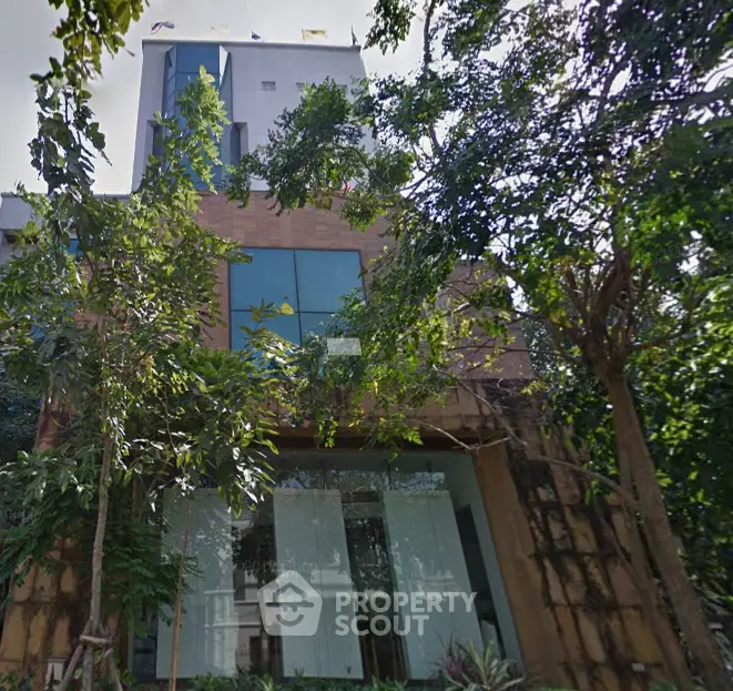 Modern building exterior with lush greenery and large glass windows