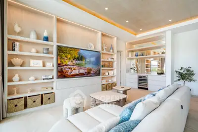 Luxurious modern living room with built-in shelves, large TV, and elegant decor.