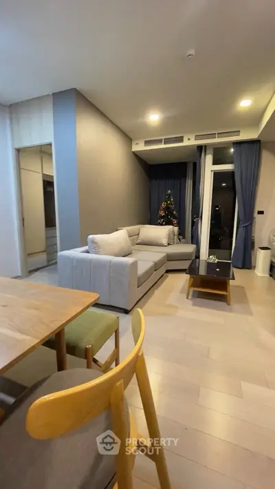 Modern living room with cozy sofa and Christmas tree, perfect for festive gatherings.